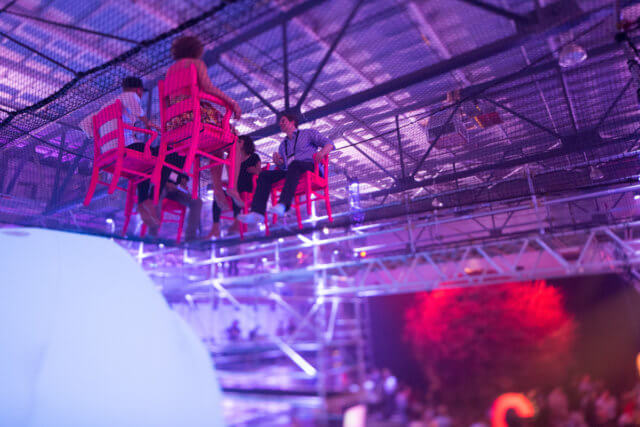 Experiential events that aren't: a photograph of two pairs of people facing  each other sitting in chairs suspended from the ceiling