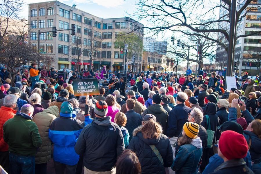 2016 photograph of a crowd of around 200 Evanston, Illinois residents and faith community members meeting at Fountain Square. The event was organized to show solidarity with those in the city feeling marginalized after the recent presidential election. Photo attribution: Daniel Tian, Senior Staffer, The Daily Northwestern